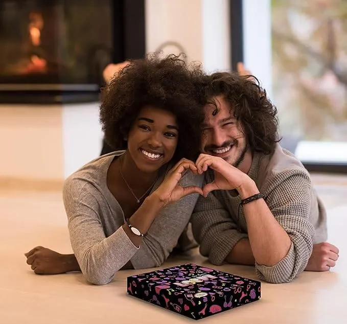 Smiling couple lying on the floor making a heart with their hands, the Loopy box in front of them